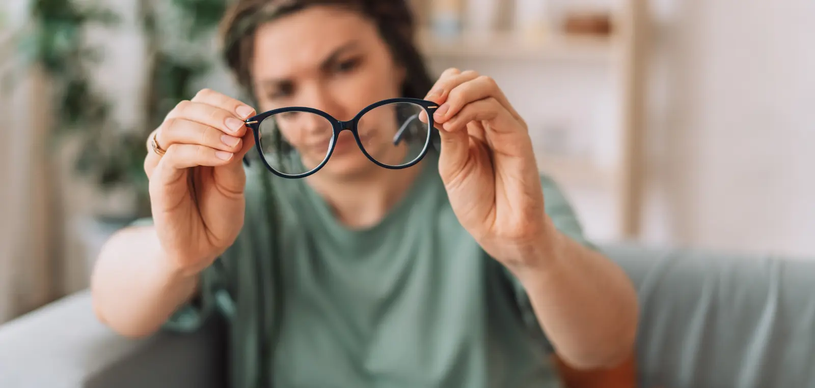 Un opticien polit une monture en acétate sur son établi avec un chiffon doux.